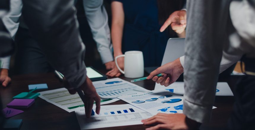 Millennial Asia businessmen and businesswomen meeting brainstorming ideas about new paperwork project colleagues working together planning success strategy enjoy teamwork in small modern night office.